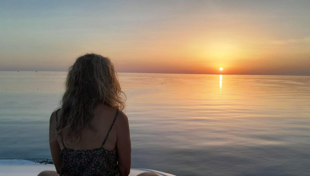 Lalitha devant l'horizon et le soleil couchant sur la mer